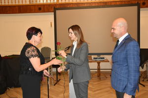 Sekretarz gminy Włoszakowice Karolina Chlebowska wręcza kwiat nauczycielce Zespołu Szkół Ogólnokształcących we Włoszakowicach Wiesławie Walkowskiej, obok stoi wójt gminy Włoszakowice Marek Wąsowicz